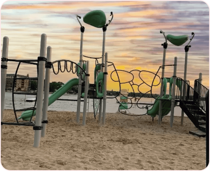 A lakeside beach playground at sunset