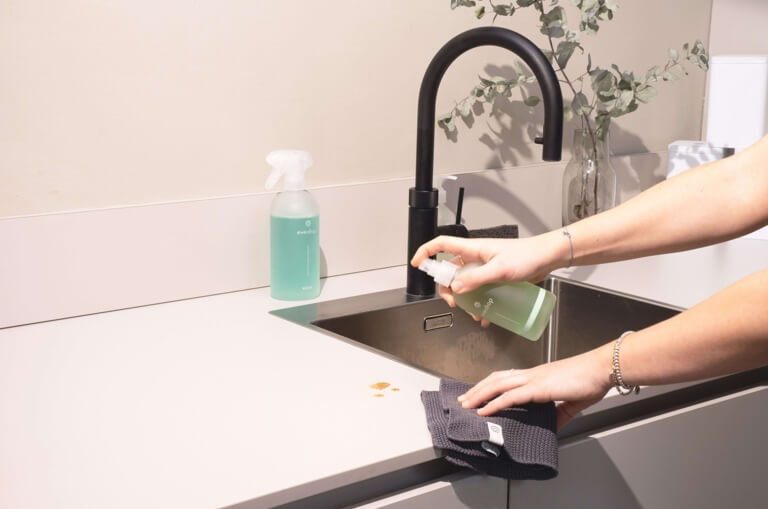 Cleaner wiping down a kitchen sink